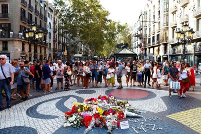 Ramos de flores y objetos depositados en el mural de Miro de La Rambla de Barcelona. ALEJANDRO GARCIA