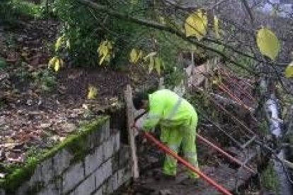 Operarios municipales, ayer en el momento de proceder a la restauración del muro deteriorado