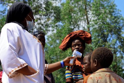 Un médico congoleño toma la temperatura a un niño antes de empezar la campaña de vacunación del ébola en la población de Beni, en el Congo.