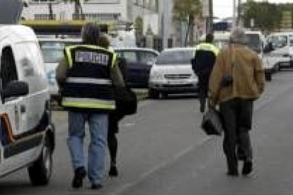 Un policía (derecha) lleva en una bolsa los restos de la bomba