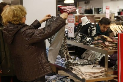 Una mujer observa una camiseta rebajada en Madrid.