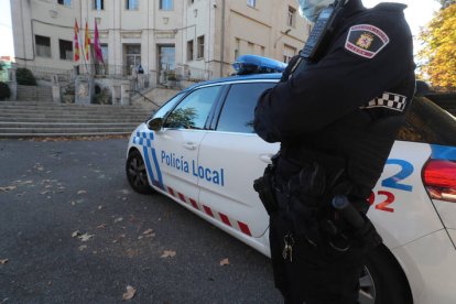 Un agente y un vehículo de la Policía Local de León. RAMIRO