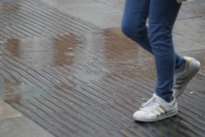 Una persona camina bajo la lluvia. J. P. GANDUL