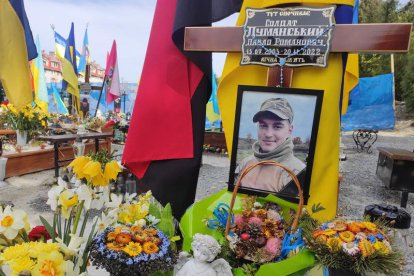 Homenaje floral de la familia de un joven combatiente en el cementerio militar de Leópolis. ROSTYSLAV AVERCHUK