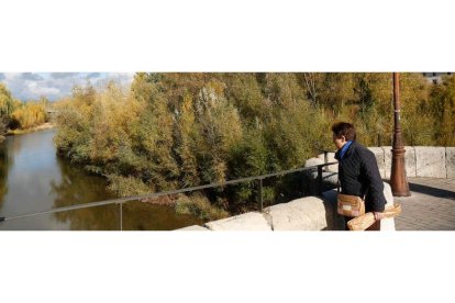 Una mujer contempla el río Bernesga a su paso por León a la altura de San Marcos. FERNANDO OTERO