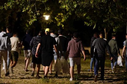 Un grupo de jóvenes con bolsas llenas de botellas para hacer un botellón. NACHO GALLEGO