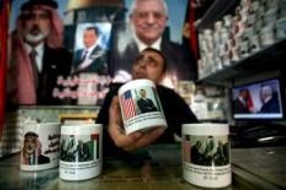 El dependiente de una tienda de Gaza muestra una taza decorada con una foto de Barack Obama