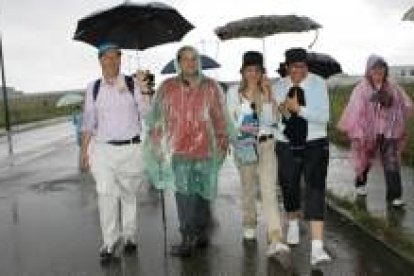 Amilivia, en el centro, tuvo que taparse para que la lluvia no le mojara en su tramo por el Camino