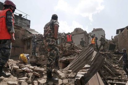 Soldados y equipos de rescate nepalís buscan supervivientes entre los escombros de los edificios caídos tras el terremoto.