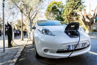 Vista de un coche eléctrico mientras carga la batería en el centro de Palma de Mallorca. LLITERES