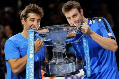 Marc López y Granollers muerden la copa que les acredita como campeones de dobles.