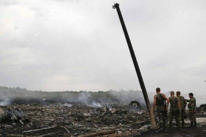 Separatistas prorrusos inspeccionan el lugar del desastre, en Grabovo, en la región de Donetsk, el jueves.