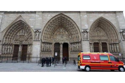 Policías franceses permanecen junto a un vehículo de los bomberos tras el suicidio en Nôtre Dame, este martes en París.