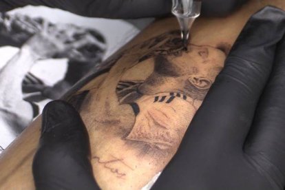 Una persona se hace un tatuaje de Lionel Messi besando la Copa del Mundo, el 20 de diciembre de 2022 en Rosario (Argentina). RODRIGO GARCÍA