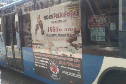 Uno de los autobuses interurbanos que luce el cartel invitando a niños, adoslescentes y adultos a conocer en primera persona el boxeo. DL