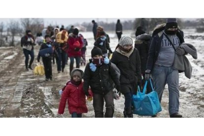 Familias de refugiados, muchos procedentes de Oriente Próximo, llegan a pie a Serbia, para continuar su viaje hacia Europa occidental, este lunes.