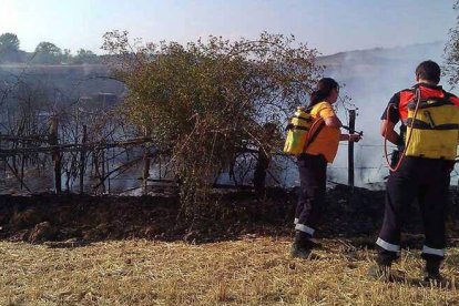 Dos agentes sofocan las llamas del incendio del pasado miércoles.