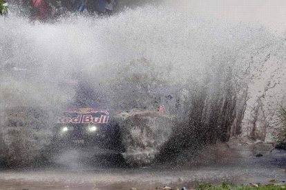 El piloto Carlos Sainz atraviesa un río en el rali Dakar.