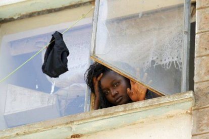 Una estudiante mira a través de una ventana en la residencia de mujeres del campus de Kikuyu, en Nairobi.