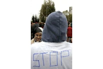 Un joven de un suburbio de París muestra su camiseta con la palabra Stop pintada a la espalda