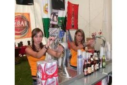 Dos jóvenes del pueblo en el momento de tirar la cerveza en la feria