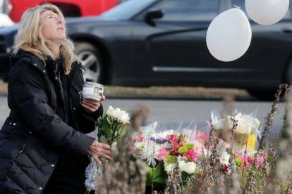 Una mujer deposita flores en el lugar del homenaje a las víctimas de la matanza.