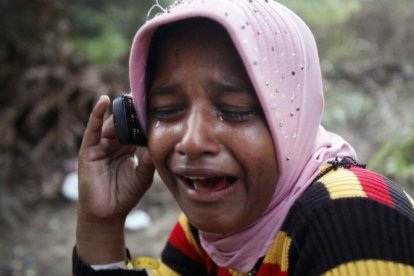 Una refugiada rohingya llora mientras habla por teléfono con su hermano.