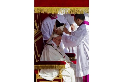 El papa Francisco (c) recibe la mitra durante la misa solemne de inicio de su Pontificado en la plaza de San Pedro del Vaticano.