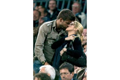 El defensa del Barcelona Gerard Piqué y su novia, la estrella colombiana Shakira, se besan durante un partido en el Camp Nou. A la derecha, la foto de la cantante embarazada que la propia Shakira colgó en su Twitter.