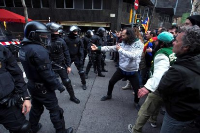 Miembros de los Mossos d´Esquadra impiden el paso de manifestantes en las inmediaciones de la Delegación del Gobierno en Barcelona, durante la protesta convocada esta tarde.