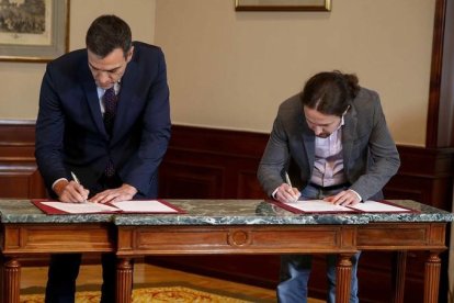 El presidente del Gobierno español en funciones, el socialista Pedro Sánchez,iz., y el líder de Podemos, Pablo Iglesias, se estrechan la mano en el Congreso de los Diputados donde hoy firmaron un acuerdo para la formación de un Ejecutivo en España tras las elecciones del pasado domingo. EFE/Paco Campos