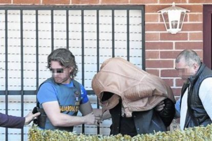 Un momento del registro en la casa pareada de Majadahonda, con el sospechoso escoltado por los agentes.