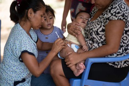 La enfermera Mercedes Parada pone una vacuna a Ciro, de 7 meses, durante una visita en 2022 en Litoral (Bolivia). RADOSLAW CZAJKOWSKITO