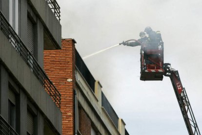 Un bombero trabaja en la extinción del incendio en la Avenida de San Mamés.