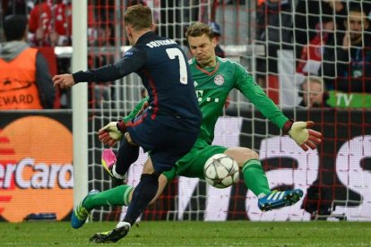 El jugador del Atlético Antoine Griezmann anota el gol del empate 1-1 ante el portero del Bayern Manuel Neuer. ANGELIKA WARMUTH