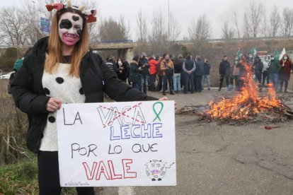 Una ganadera sostiene una pancarta para reivindicar un precio justo para la leche de vacuno. RAMIRO