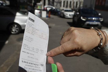 Una mujer muestra el descuento aplicado en la factura tras repostar en una estación de servicio. EMILIO NARANJO