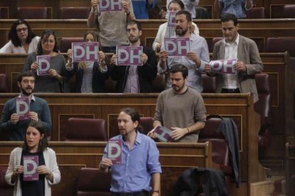 Diputados de Podemos muestran carteles a favor de los derechos humanos al inicio del pleno del Congreso.