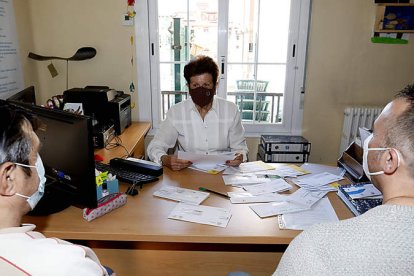 Tere la voluntaria de la Sociedad de San Vicente de Paúl atiende a dos personas sin hogar en la sede de la calle San Pedro, 19. MARCIANO PÉREZ