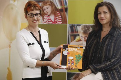 María Jesús Soto y Raquel López Varela, con un ejemplar de ‘Mi primer libro de economía, ahorro e inversión’. RAMIRO