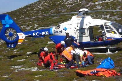 Rescatadores y personal sanitario trasladan al herido al helicóptero medicalizado.