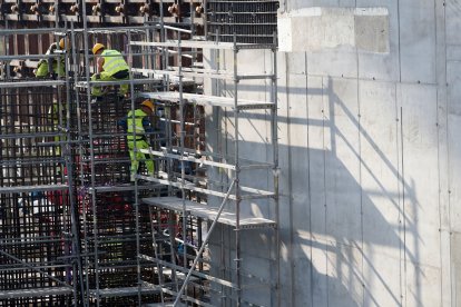 Fotografía de archivo de unos trabajadores de la construcción suspendidos a cierta altura sobre unos andamios. TOMS KALNINS