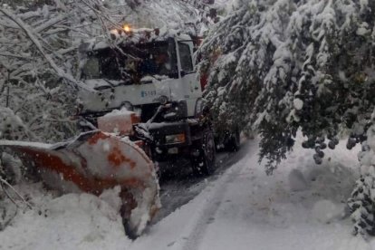 Una máquina quitanieves trabaja para despejar la vía de nieve y ramas en el municipio de Posada de Valdeón. DL