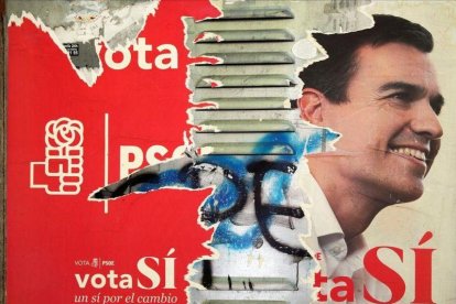 Uno de los carteles que los socialistas utilizaron en campaña electoral, ahora deteriorado, con la imagen de Pedro Sánchez.