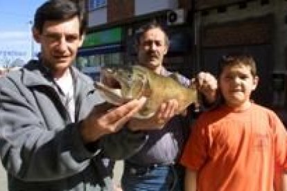 La foto muestra a los tres partícipes en la captura de la preciada trucha