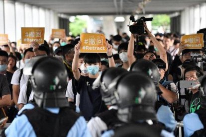 Un grupo de manifestantes sostienen pancartas de protesta contra la policía hongkonesa, este jueves.