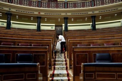 Labores de limpieza en el hemiciclo del Congreso de los Diputados, tras quedarse vacío el pasado 28 de febrero.