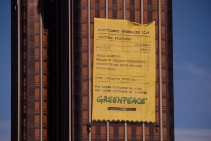 La pancarta de casi 300 metros cuadrados que ha desplegado Greenpeace en la fachada de las torres de Colón.