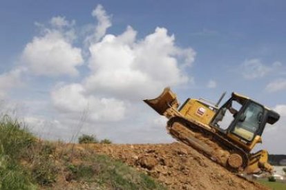 El ingeniero de la federación Internacional, en el bulldozer con el que se ha configurado el trazado