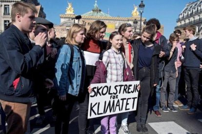 La activista sueca Greta Thunberg sostiene una pancarta junto a varios estudiantes franceses que participan en una marcha contra el cambio climático en París, el 22 de febrero.